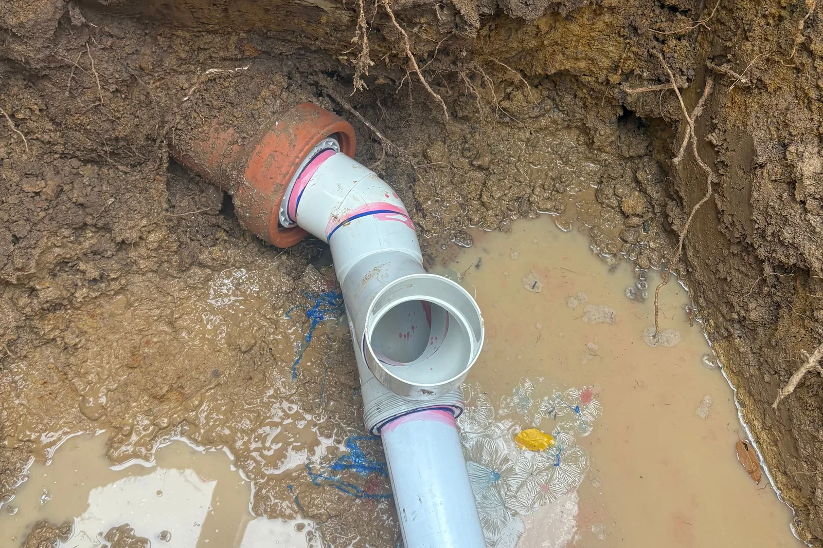 Excavated drain line being repaired on site